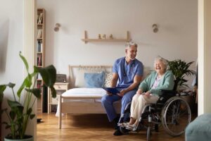 A group of seniors sitting together in a light-filled common room, talking with a healthcare professional.