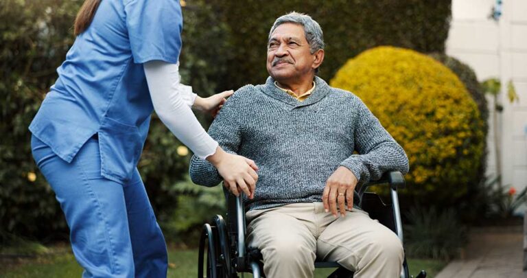 Older adult and family member reviewing care options at a table with a caregiver nearby.